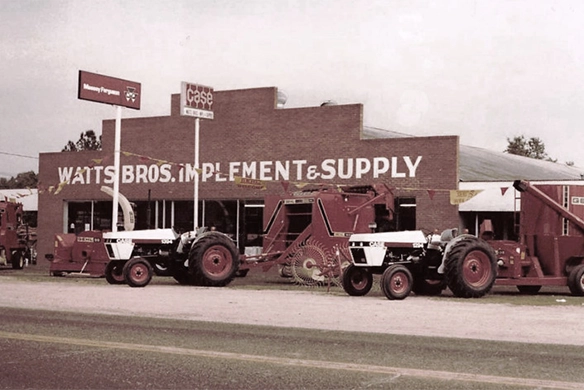 Vintage photo of Watts Bros Implement and Supply building with Case and Massey Ferguson signage from 1940s